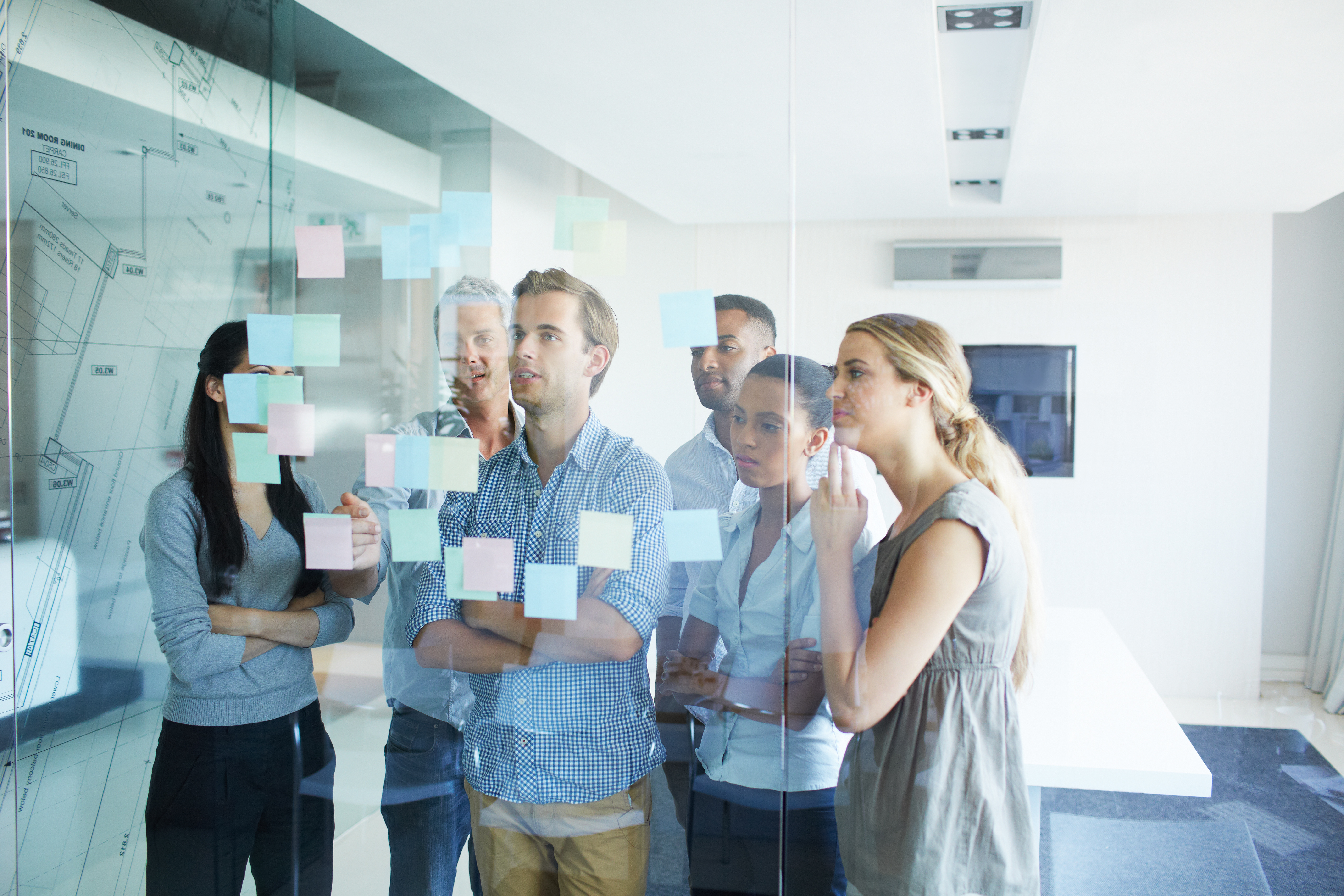 Shot of a group of colleagues brainstorming together with sticky notes in an office