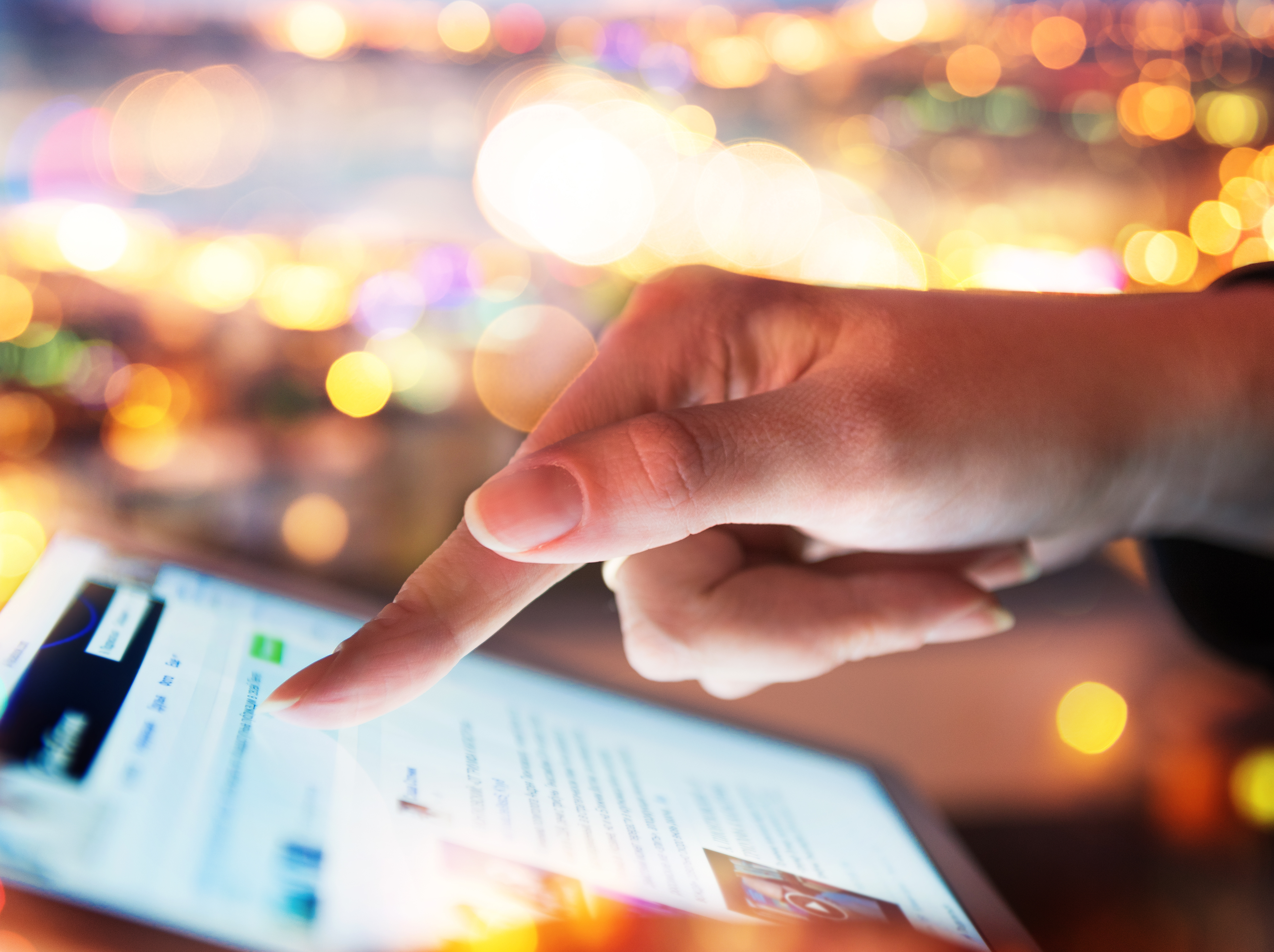 Woman hand hold and touch screen tablet on abstract blurred city night light background